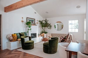 Fireplace-in-a-modern-living-room-with-two-bold-curved-chairs-and-plants-and-fresh-flowers
